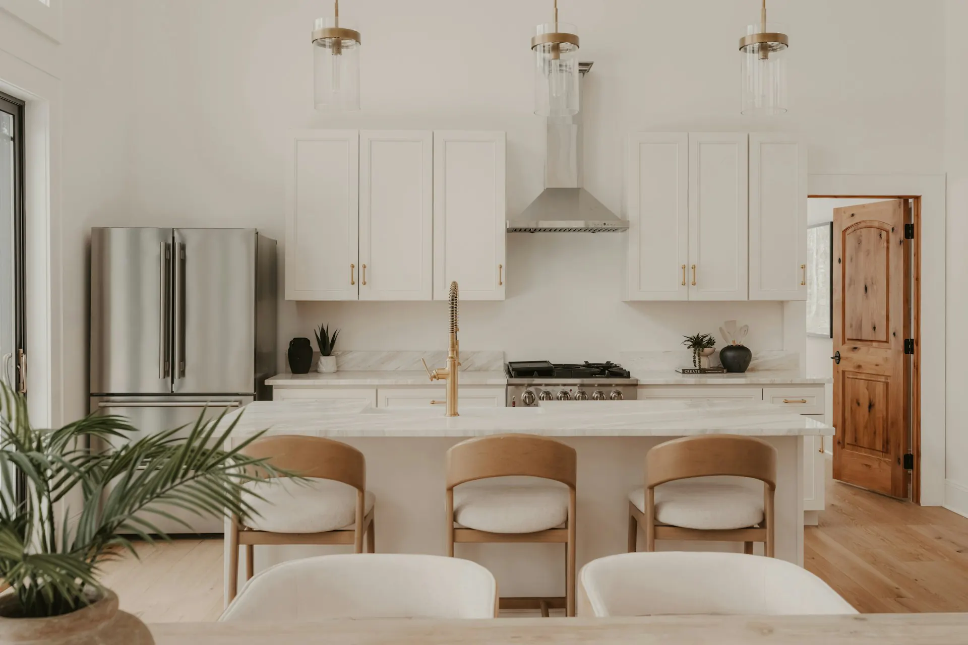 Modern white kitchen with stainless steel appliances and island — representative of the products a homeowner evaluates on a showroom visit